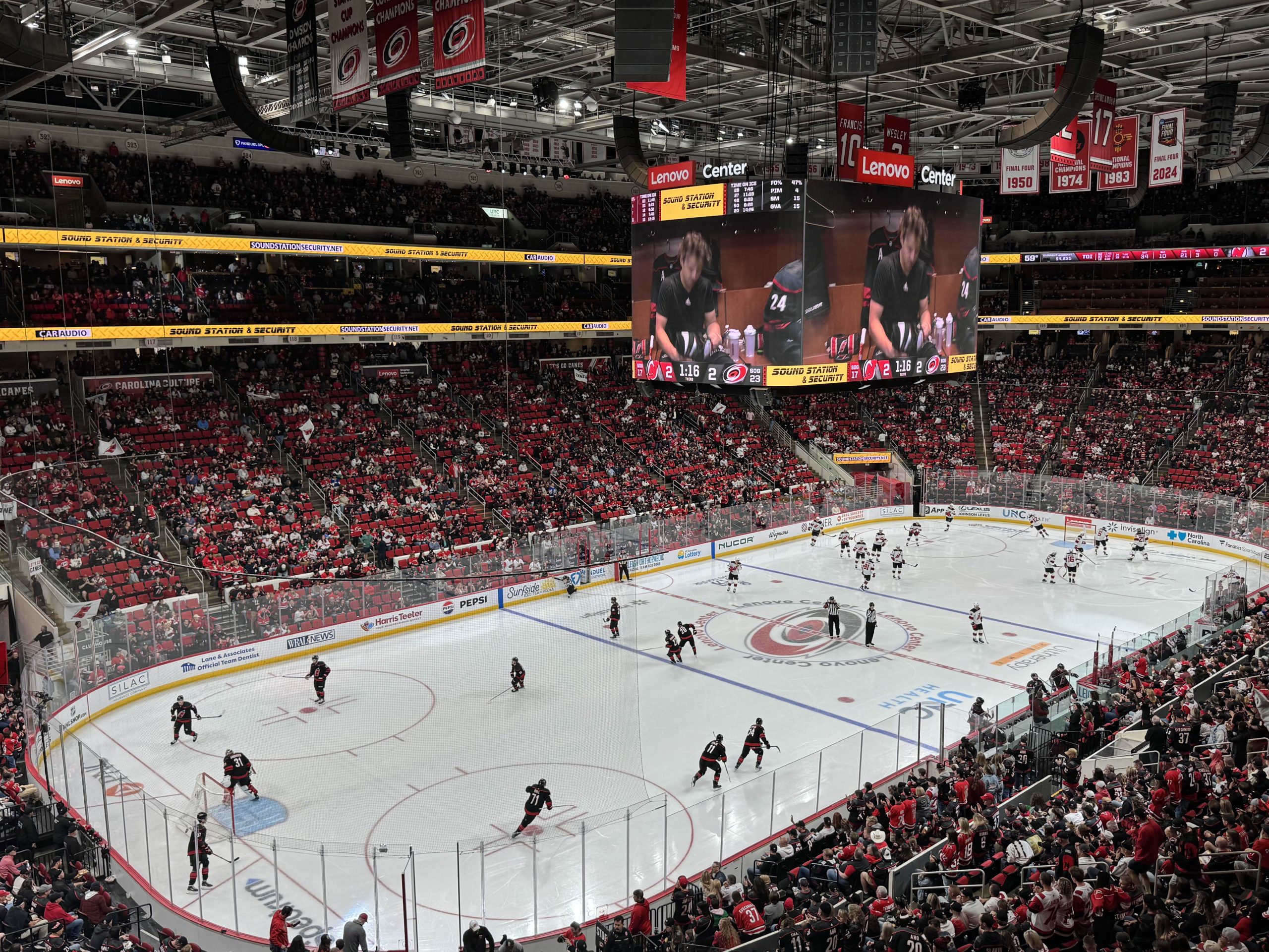 A view of the Carolina Hurricanes hockey game, showing the arena and players.